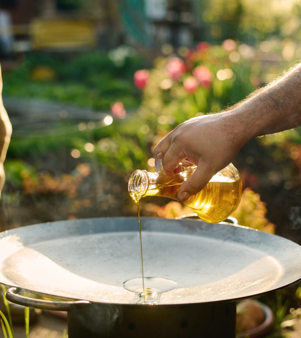 Man pouring olive oil on frying pan
